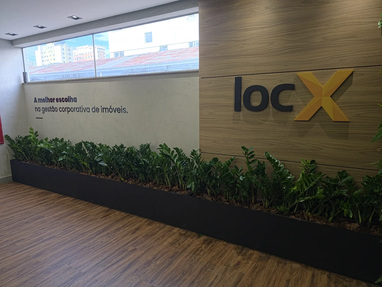 Painel corporativo em madeira com identidade visual e jardineira